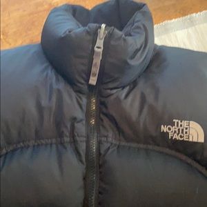 Woman’s North Face black down jacket.